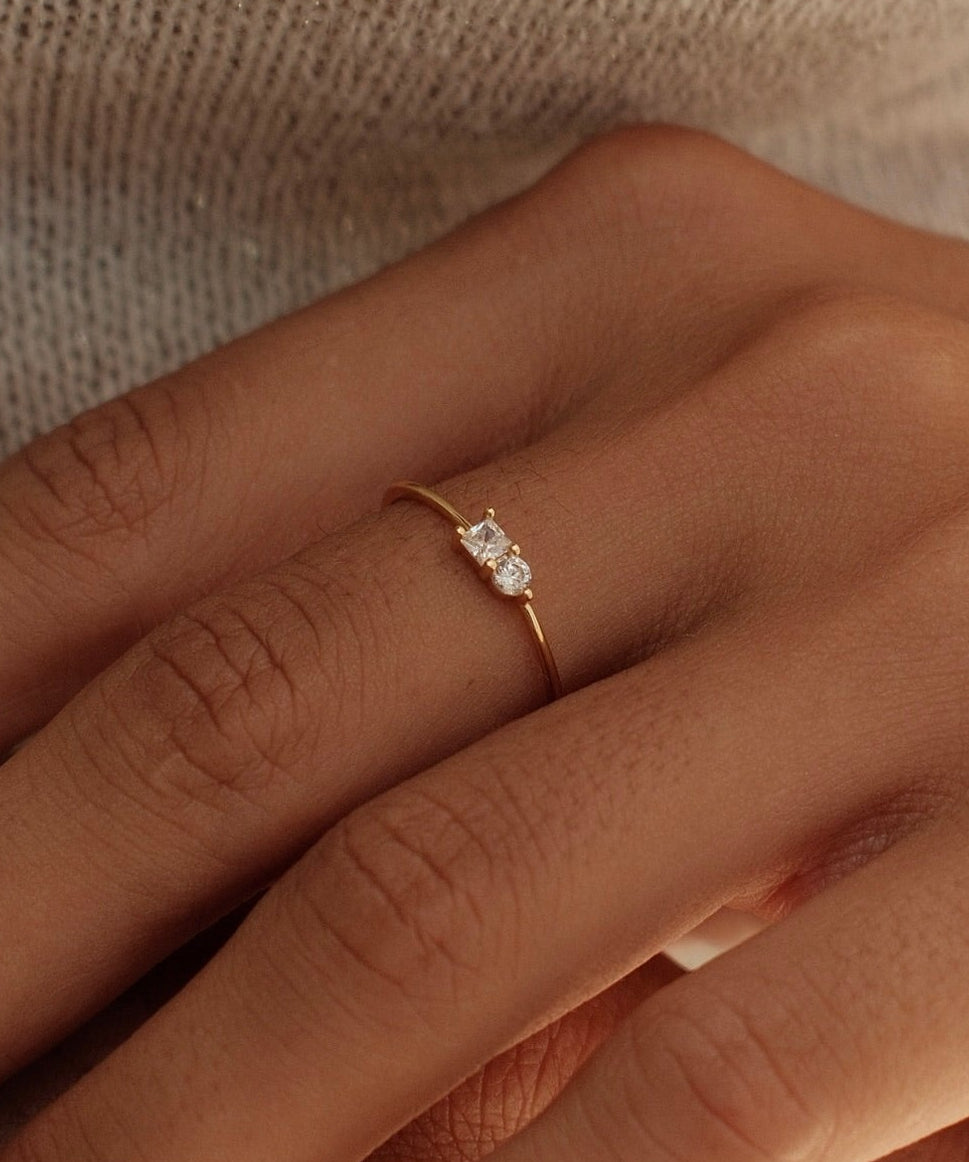Close-up of two hands with a ring on a neutral background