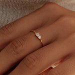 Close-up of two hands with a ring on a neutral background