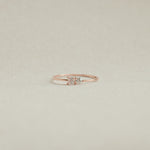 Rose gold ring with a diamond on a beige background