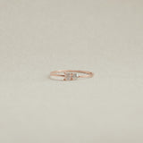 Rose gold ring with a diamond on a beige background